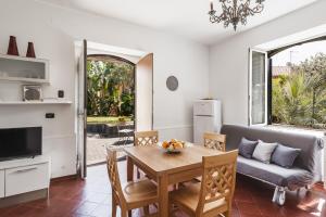 uma sala de estar com uma mesa e um sofá em City Cottage with Garden & Pool by Wonderful Italy em Catânia
