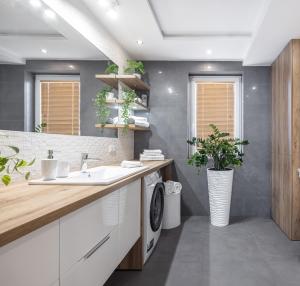 a bathroom with a sink and a washing machine at Mevka Apartamenty Mosty in Mosty