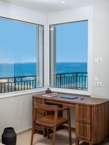 a desk and chair in a room with windows at Zuzu Riviera Living in Hersonissos