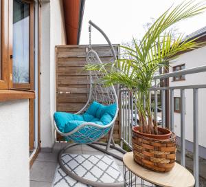 a swing on a balcony with a plant at Mevka Apartamenty Mosty in Mosty