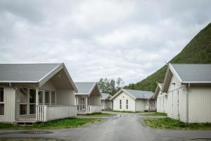 eine Reihe von Häusern mit Bergen im Hintergrund in der Unterkunft Tromsø Lodge & Camping in Tromsø