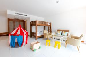 Pinnacle Grand Jomtien Resort and Beach Club - SHA Extra Plus في نا جومتين: غرفة فيها خيمة وسرير وكراسي