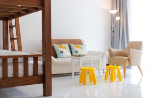 Pinnacle Grand Jomtien Resort and Beach Club - SHA Extra Plus في نا جومتين: غرفة معيشة مع سرير وطاولة وكراسي