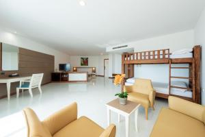 Pinnacle Grand Jomtien Resort and Beach Club - SHA Extra Plus في نا جومتين: غرفة معيشة مع أريكة وسرير بطابقين