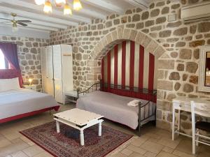 a bedroom with two beds and a stone wall at Myral Guesthouse in Nafplio