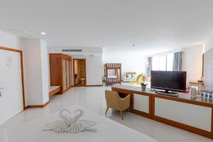 een woonkamer met een bureau en een televisie. bij Pinnacle Grand Jomtien Resort and Beach Club - SHA Extra Plus in Na Jomtien