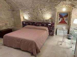 a bedroom with a bed and a stone wall at Suite Duomo Trani 6 in Trani