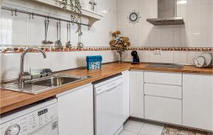 a kitchen with white cabinets and a sink at 2 Bedroom Lovely Apartment In Chipiona in Chipiona
