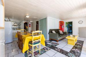 Il dispose d'une cuisine et d'un salon avec une table et des chaises jaunes. dans l'établissement Gîte 1 à la Maison Mosaïc, à Gaillan-en-Médoc