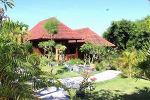 a house with a red roof and a garden at Bamboo Bungalow Jungle View in Nusa Penida
