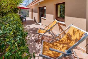 two chairs sitting on a patio next to a building at CASA BELL - Appartamento con parcheggio privato e bike room in Finale Ligure