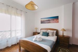 a bedroom with a bed and a large window at Best Houses 85 - Sea breeze at Consolação Beach in Atouguia da Baleia