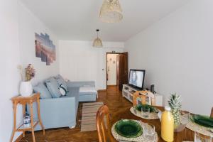 a living room with a blue couch and a table at Best Houses 85 - Sea breeze at Consolação Beach in Atouguia da Baleia