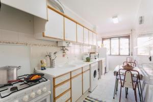a kitchen with white cabinets and a sink and a stove at Best Houses 85 - Sea breeze at Consolação Beach in Atouguia da Baleia +14 photos