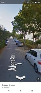 a street with cars parked on the side of the road at Apartament Amurg in Dej