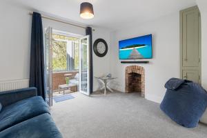 a living room with a blue couch and a fireplace at Exe Riverside Retreat Holiday Home in Exeter