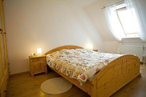 シャルボイツにあるReihenhaus-Aalwegのベッドルーム1室(木製ベッド1台、窓付)