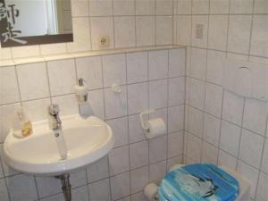 ein weißes Bad mit einem Waschbecken und einem WC in der Unterkunft Reihenhaus Aalweg in Scharbeutz