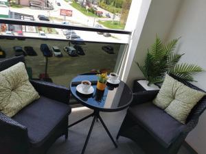 a balcony with a table and chairs and a view of a street at Alex LUX in Banja Luka