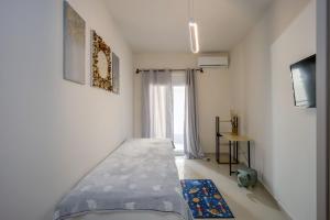 a small bedroom with a bed and a window at Downtown Guesthouse by Estia in Heraklio Town