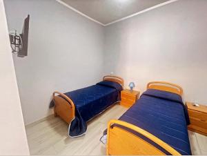 Un dormitorio con dos camas con sábanas azules. en M&C Apartment, en Fiumicino