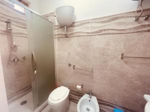 een badkamer met een toilet, een douche en een wastafel bij M&C Apartment in Fiumicino