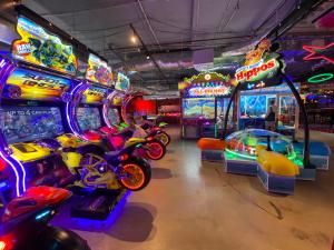 a room with many arcade games and a motorcycle in it at Oceanfront Family Apartment Pool & BBQ in Gold Coast