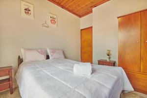 a bedroom with a large white bed with a wooden ceiling at Villa Roxa Montuoso in Agios Leon