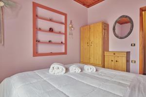 a bedroom with a white bed with towels on it at Villa Roxa Montuoso in Agios Leon
