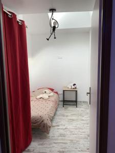 - une chambre avec un lit et un rideau rouge dans l'établissement Maison entière avec sauna privatif Sauna sur Sye, à Aouste-sur-Sye