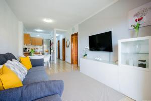 een woonkamer met een blauwe bank en gele kussens bij Palm Mar Romantic Suite A11 in Palm-mar