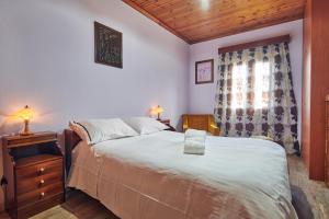 a bedroom with a large bed and a window at Villa Roxa Montuoso in Agios Leon