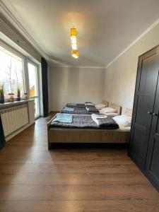 a bedroom with a large bed and a large window at Apartament Ogrodowa in Muszyna