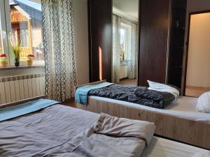 a room with two beds and a window at Apartament Ogrodowa in Muszyna