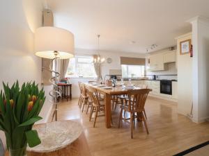 a kitchen and dining room with a table and chairs at Walnut House in Lowestoft