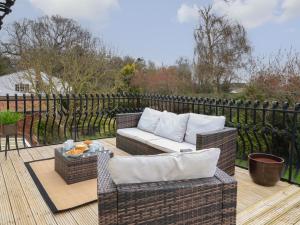 a patio with wicker chairs and a couch on a deck at Walnut House in Lowestoft