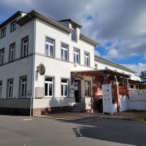 un edificio blanco con un cartel delante en Monteurunterkunft Schützenhaus Leisnig, en Leisnig