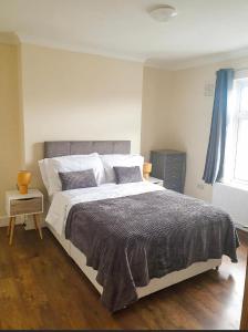 Un dormitorio con una cama grande y una ventana en 2 Bedroom Apartment 2 Min Walk to Station - longer stays available, en Gravesend