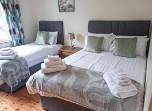 sypialnia z 2 łóżkami i ręcznikami w obiekcie Shannons Gate w mieście Killorglin