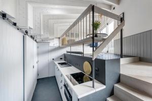 een keuken met witte muren en een trap bij Deep Lock Studio in Bath
