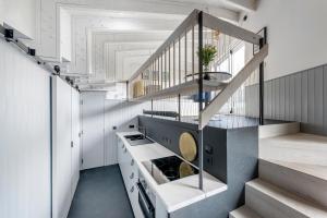 una cocina con paredes blancas y una escalera en Deep Lock Studio, en Bath