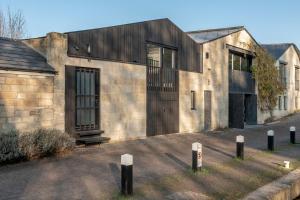 a stone building with a black door and windows at Deep Lock Studio in Bath
