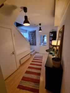 a hallway with a door and a rug on the floor at Hus i naturskjønne omgivelser in Hopen