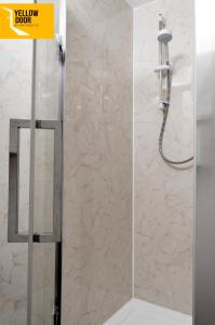 a shower with a glass door and a shower head at Blackie's Neuk - Ideal for Uni & West End in Dundee