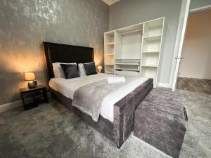 a bedroom with a large bed and shelves in it at Premium 2BR Flat in the City Centre in Glasgow