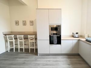 a kitchen with white cabinets and a microwave at Premium 2BR Flat in the City Centre in Glasgow