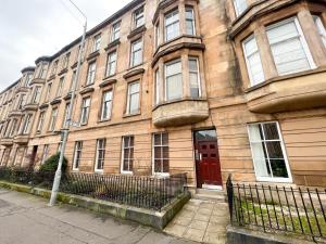 a large brick building with a red door at Premium 2BR Flat in the City Centre in Glasgow