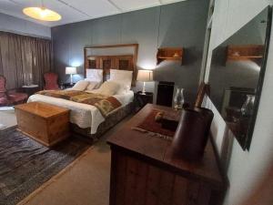 1 dormitorio con 1 cama, vestidor y escritorio en Kameel Rust and Vrede B & B, Camping and Venue, en Stella