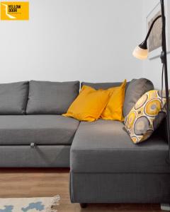 a gray couch with yellow pillows in a living room at Blackie's Neuk - Ideal for Uni & West End in Dundee