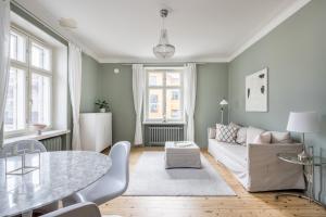 uma sala de estar com uma mesa e um sofá em Prestige City Home em Helsinque